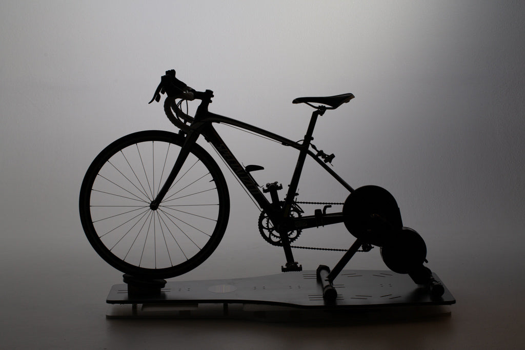 Silhouette of bike and smart trainer on Velocity Rocker, side view.